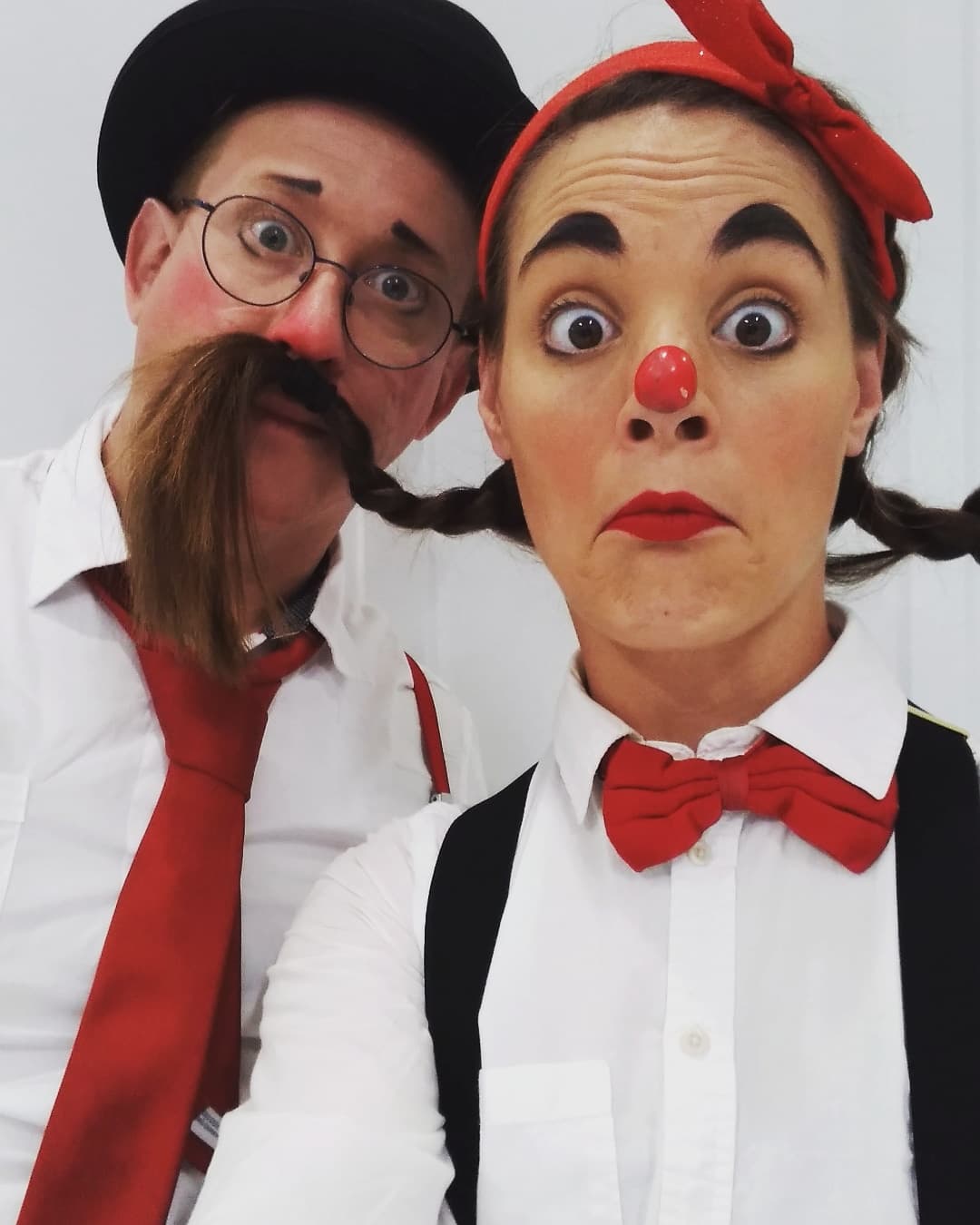 A male and female clown making silly expressions.