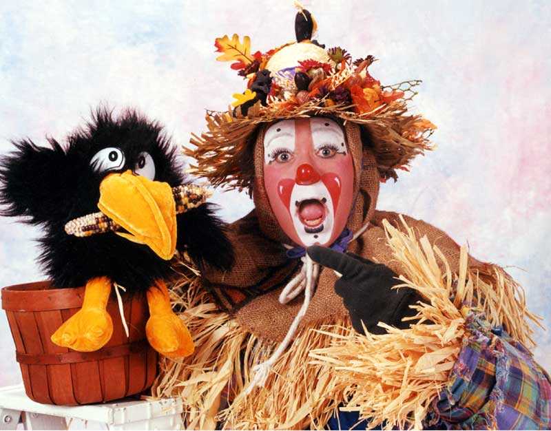 Scarecrow clown with a blackbird puppet.