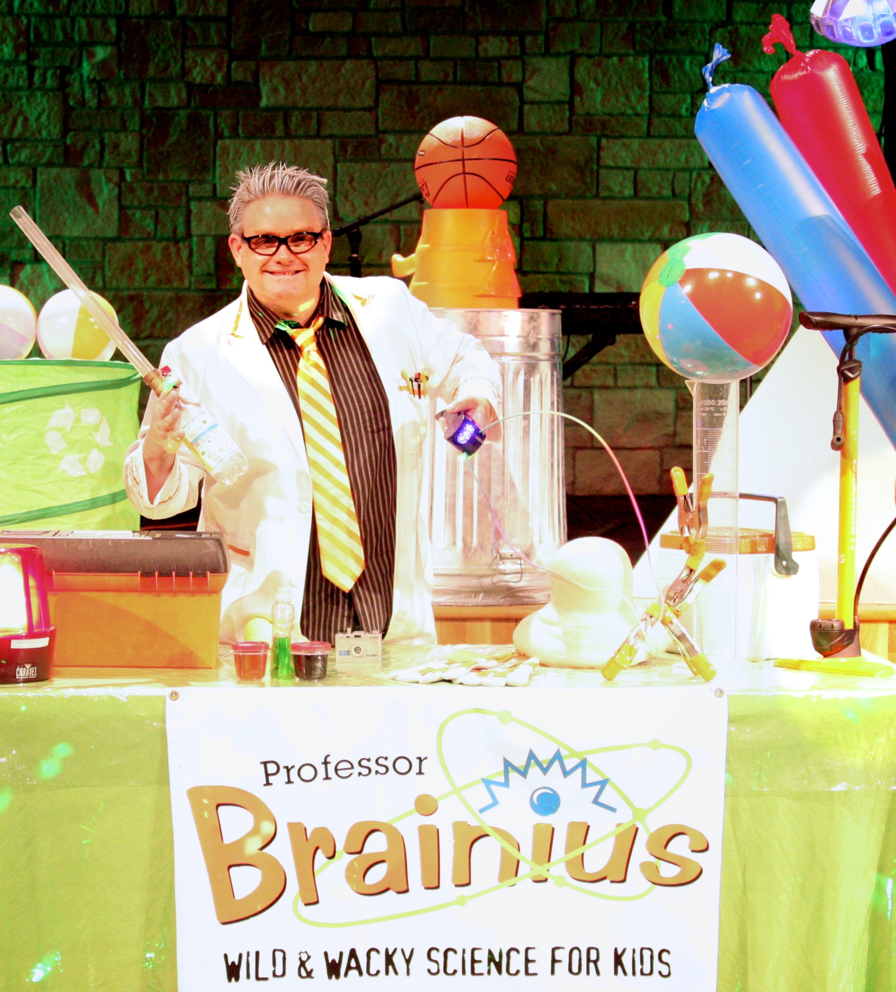 professory brainius at a table of science items