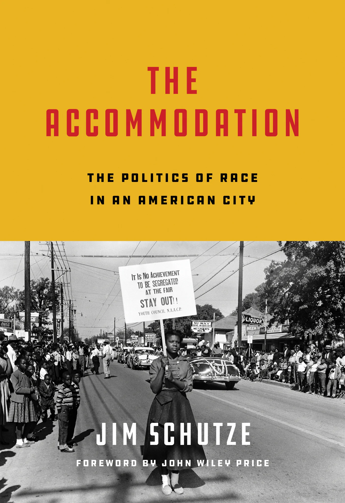 Cover image of the book, The Accommodation: The Politics of Race in an American City by Jim Schutze. It shows an image of a person holding a sign that says "It is no achievement to be segregated at the fair/Stay Out!/ Youth Council NAACP"