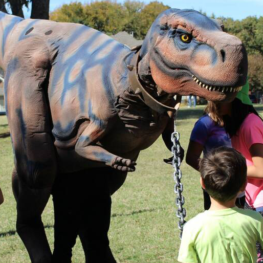 A large dinosaur being observed by children.