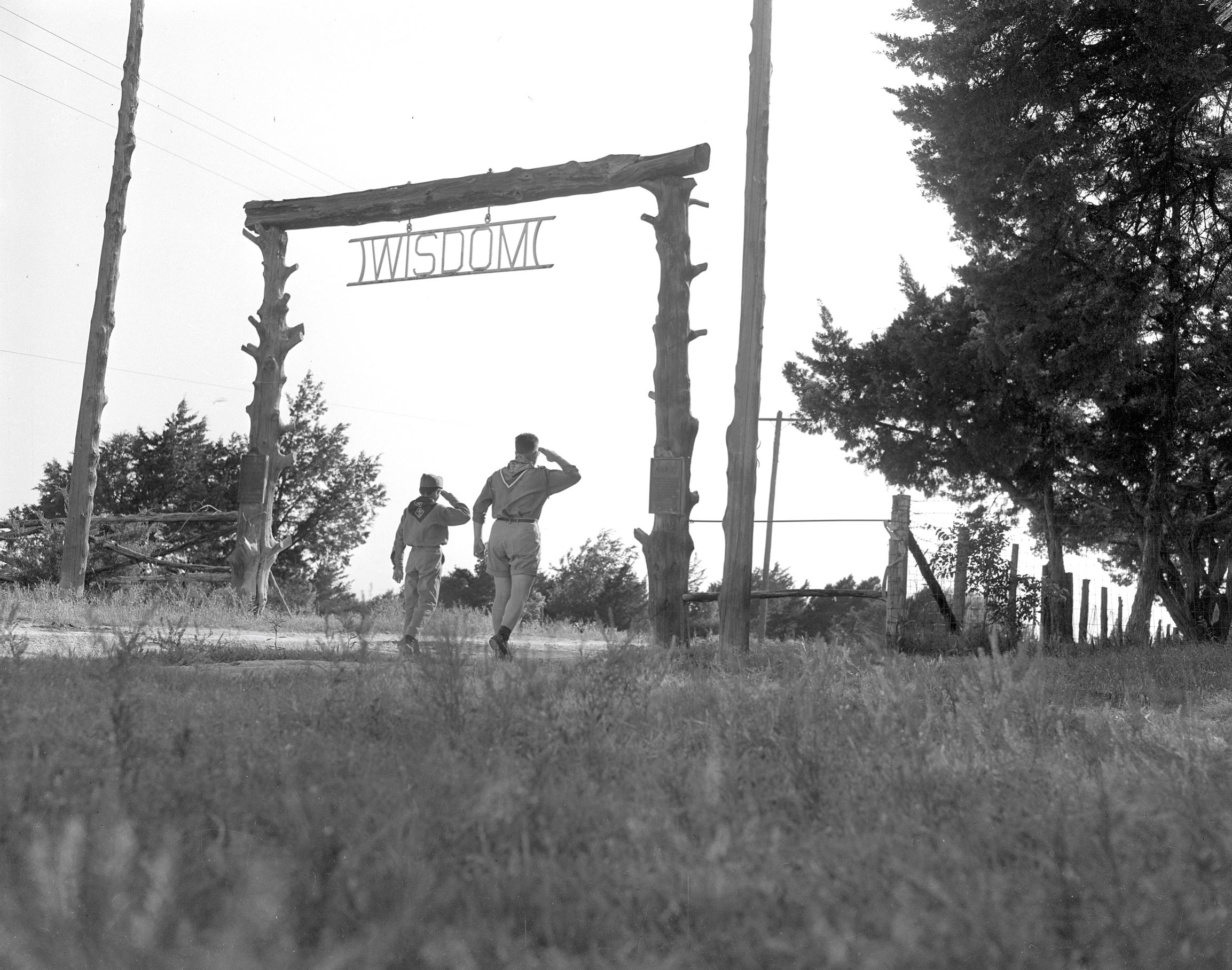 Two Boy Scouts saluting at the entrance gate of Camp Wisdom,  Dallas, 1951. From the Hayes Collection, Dallas History & Archives