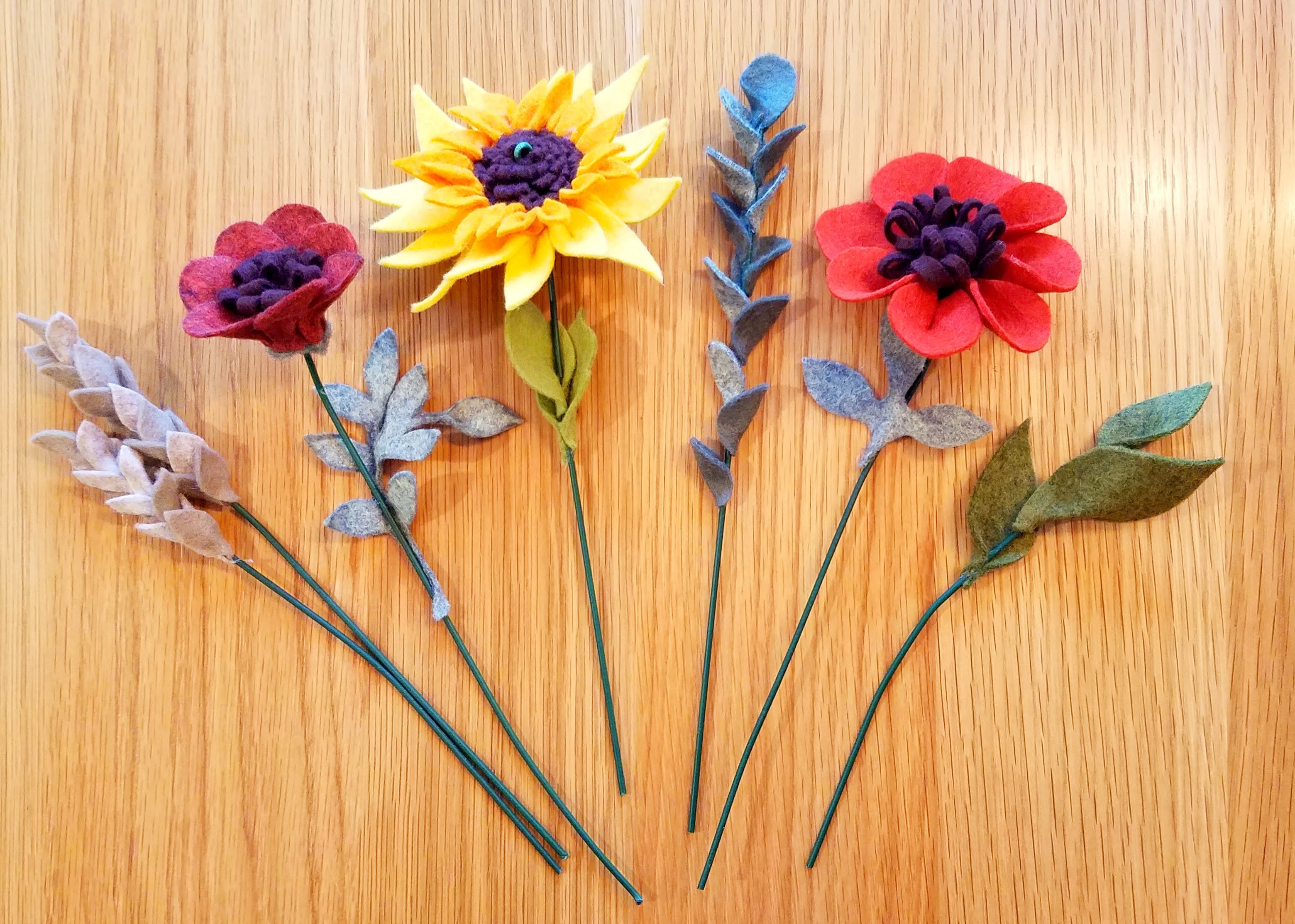 six felt flowers varying in type and color