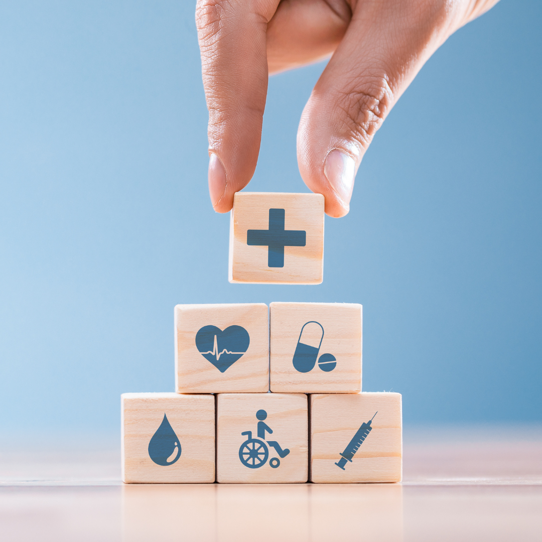 A stack of wooden blocks with symbols on them representing healthcare topics.