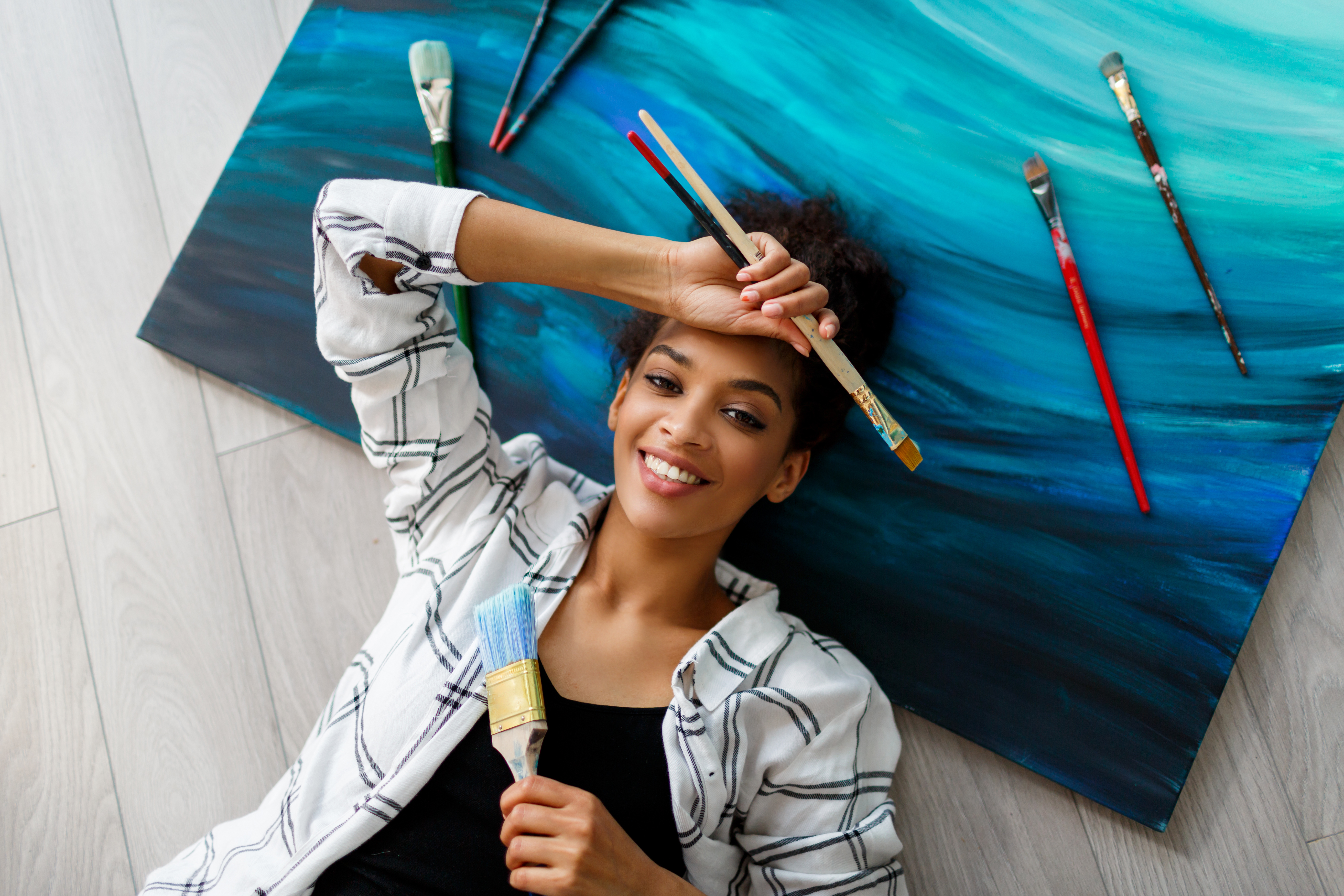 Teen Lying on a Painted Canvas