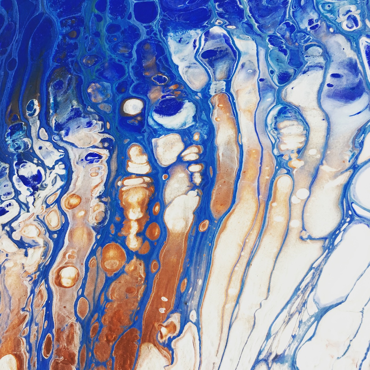 Close up image of a blue and orange paint pouring artwork