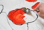 painting a read flower with a spoon