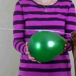 person holding green balloon on a string