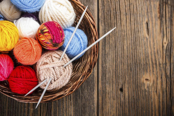 Basket of yarn with knitting needles.