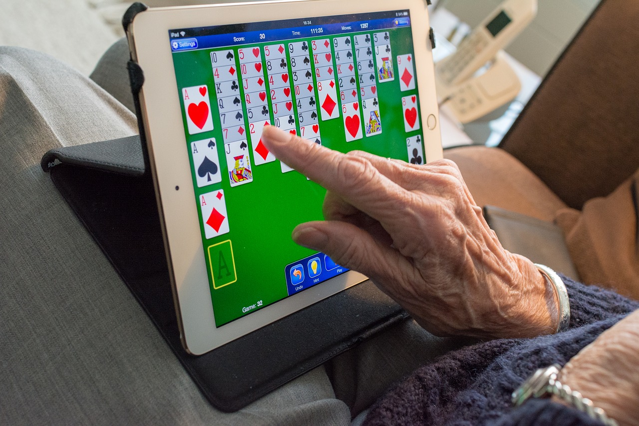 Elderly hand holding a tablet playing Ma-Jong