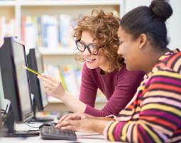 library worker helping customer on computer