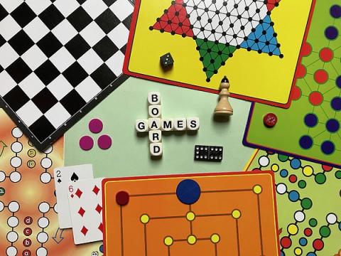 Various board games and puzzles arraged around dice that read: "Board Games."