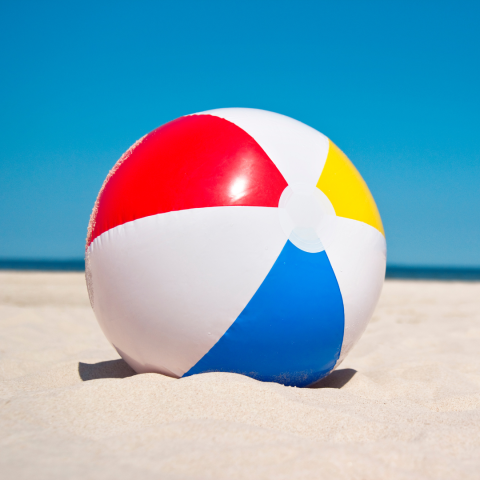 A beach ball in the sand.