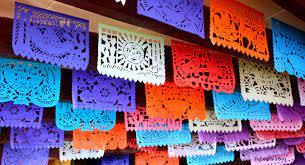 Colorful papel picado with intricate designs hang in horizontal rows.