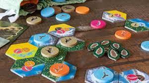A selection of multi-color game pieces set out on a wooden table. 