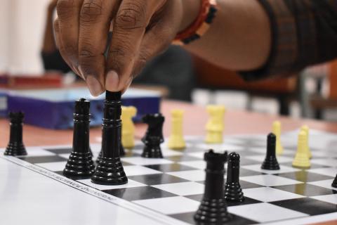 hand touch a chess piece on a chess board