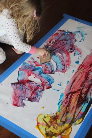 kid using cardboard and paint create art