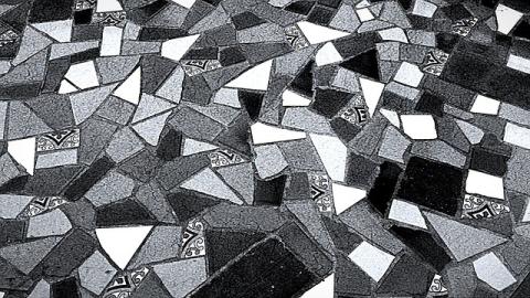 A black, white, and gray geometric pattern made of tile pieces.