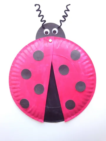 red and black painted plate with curly antennas and google eyes