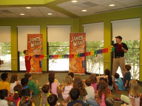 magician and volunteer holding banner