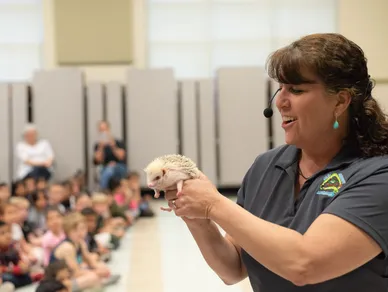 a presenter holding a small rodent