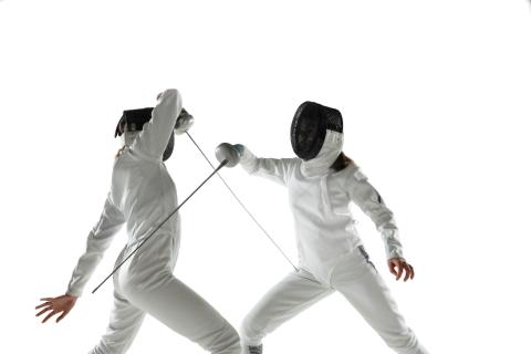 two fencers in the middle of a dual on a white background