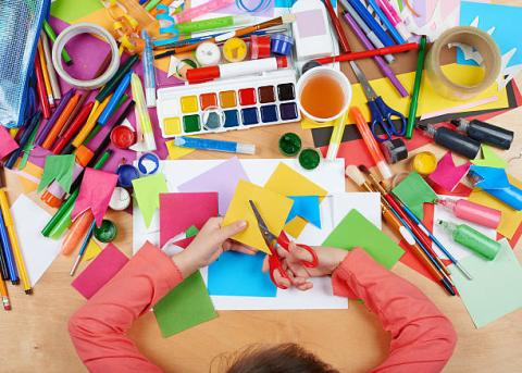 Kid with various art supplies 