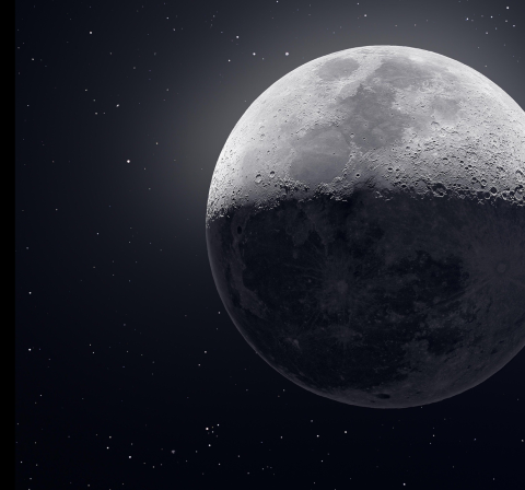 The moon with sunlight on the top half with a starry space backdrop