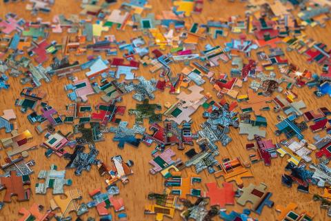 unconnected puzzle pieces in variety of color on a table