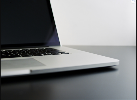 silver laptop computer sitting open on black desk 