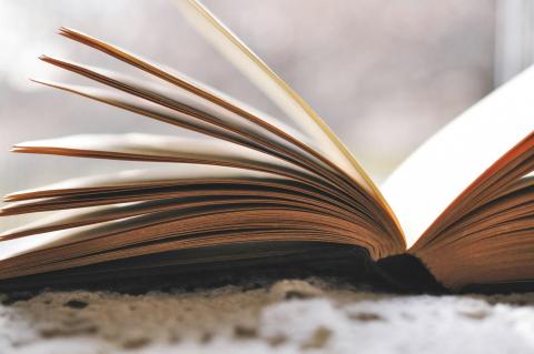 book open on table with pages fanned out