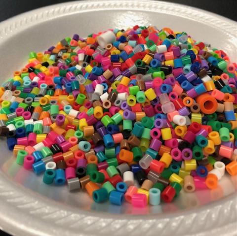 variety of colorful, small beads on a plate