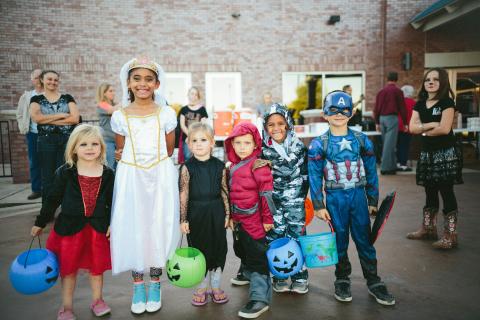 line of kids in costumes at a trick or treat event