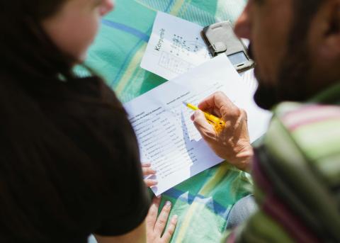 two people discussing something while pointing to a paper