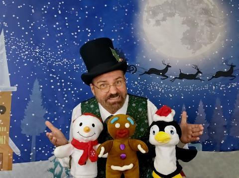 Brett Roberts holding holiday puppets with a winter background