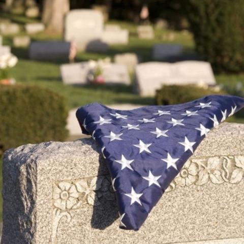 a folded veterans flag on a gravestone