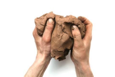 hands melding a piece of natural clay