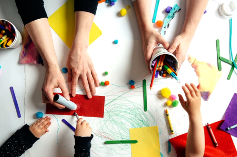 toddler and parents working on craft together