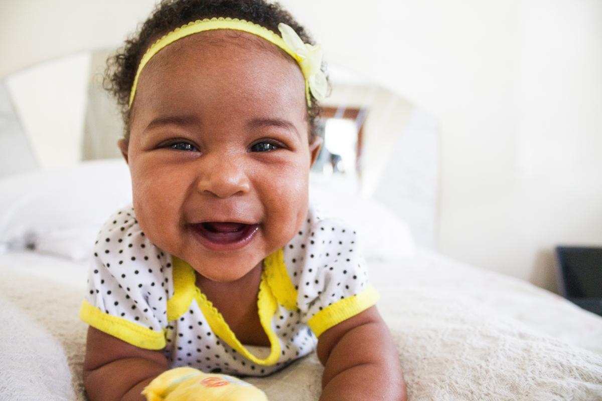 Laughing baby lying on her belly.