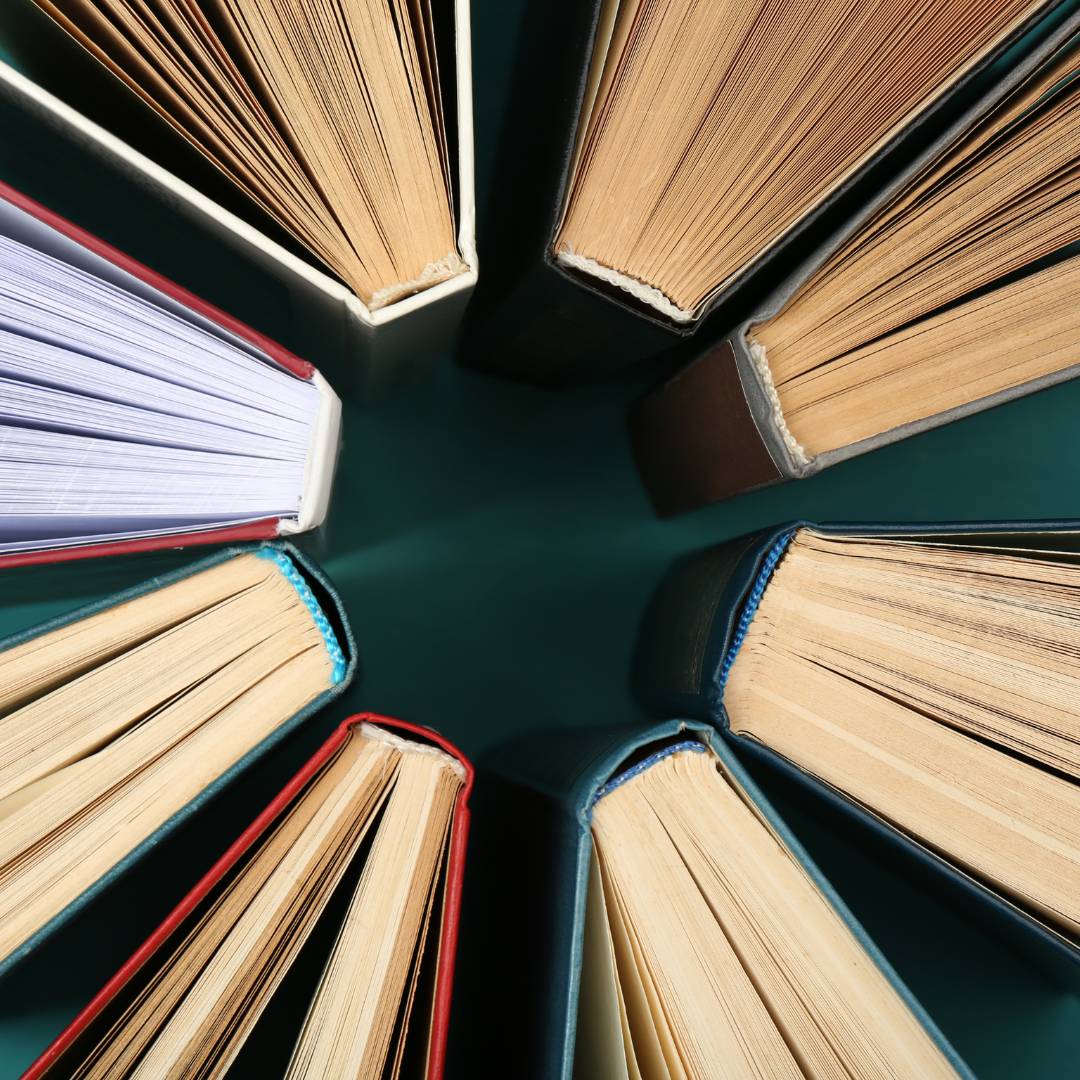 Several books arranged standing up with the spines forming a circle.