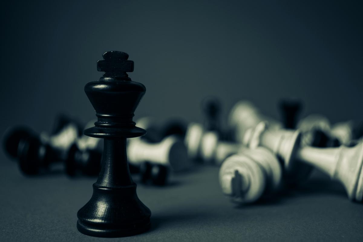 A darkly lite photo of several chess pieces.