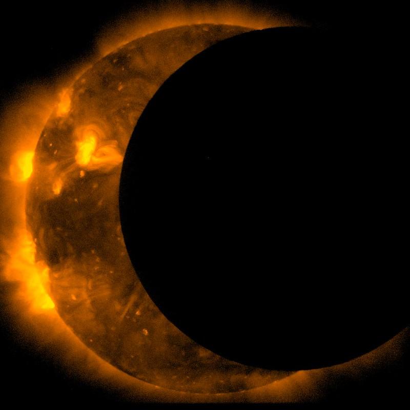 A detailed image of an eclipse. The sun has been blocked out until it is a crescent shape. Solar flares shoot off the sun into space. The moon is just a large black circle.