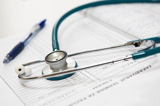 A stethoscope and pen sit on a doctor’s log of patients.