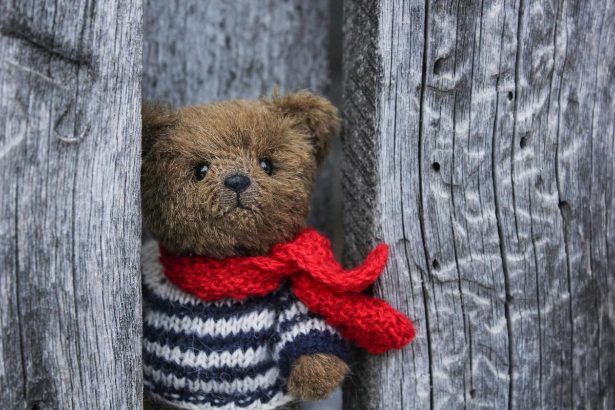 teddy bear with a striped sweater and red scarf