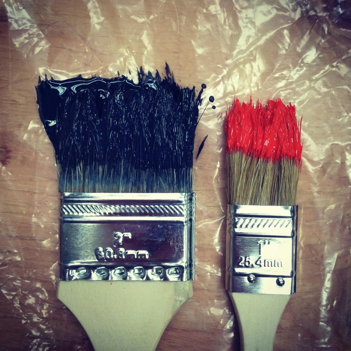 big and small paint brushes with paint on them