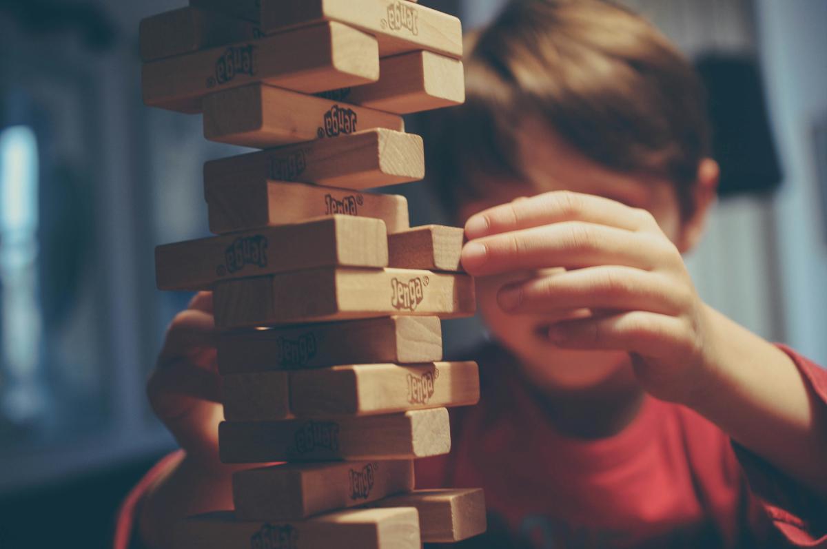 young person playing the tower block game Jenga