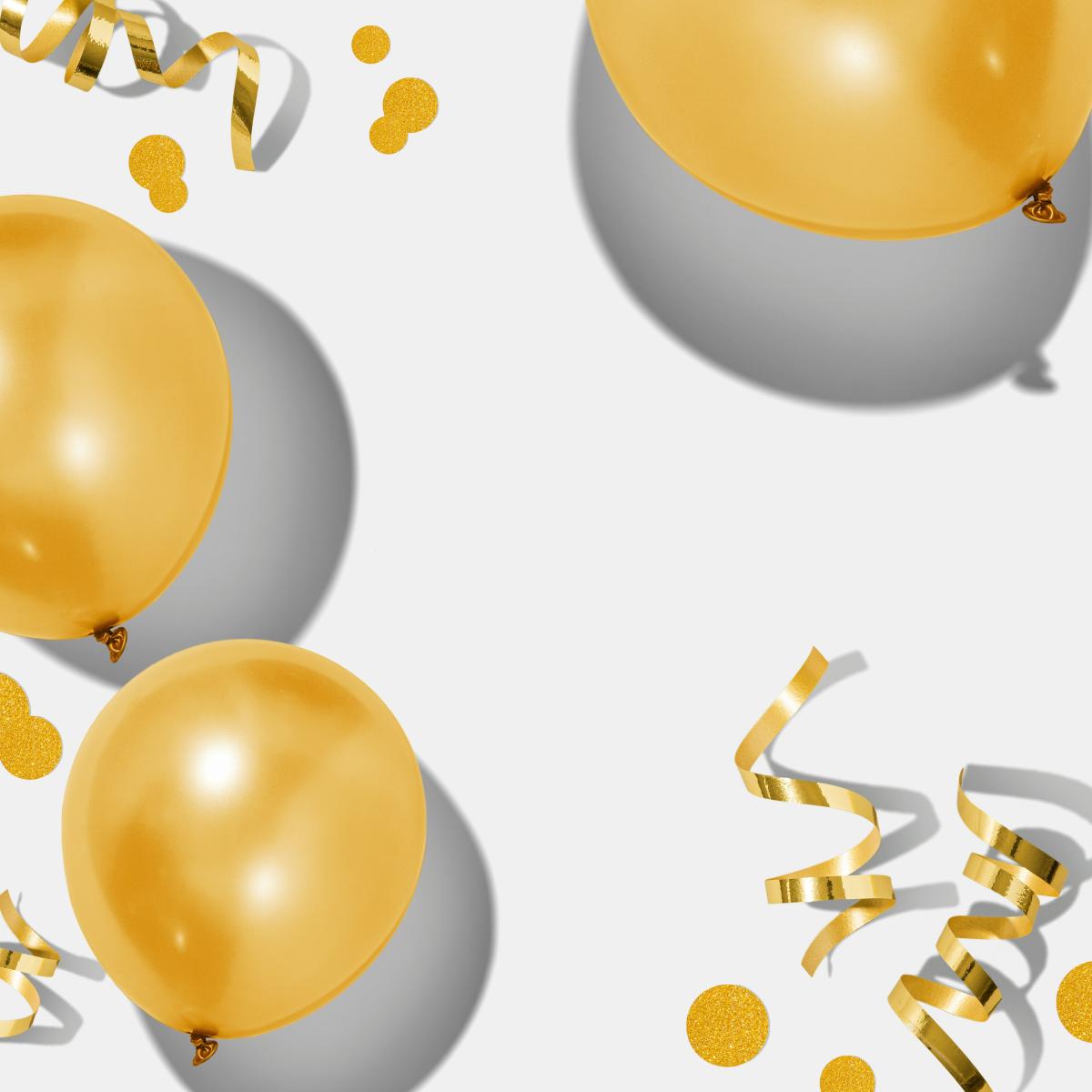 gold balloons and confetti on a white floor