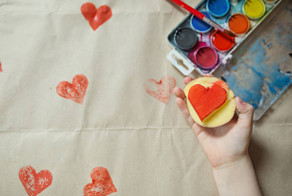 kid holding heart shape stamp