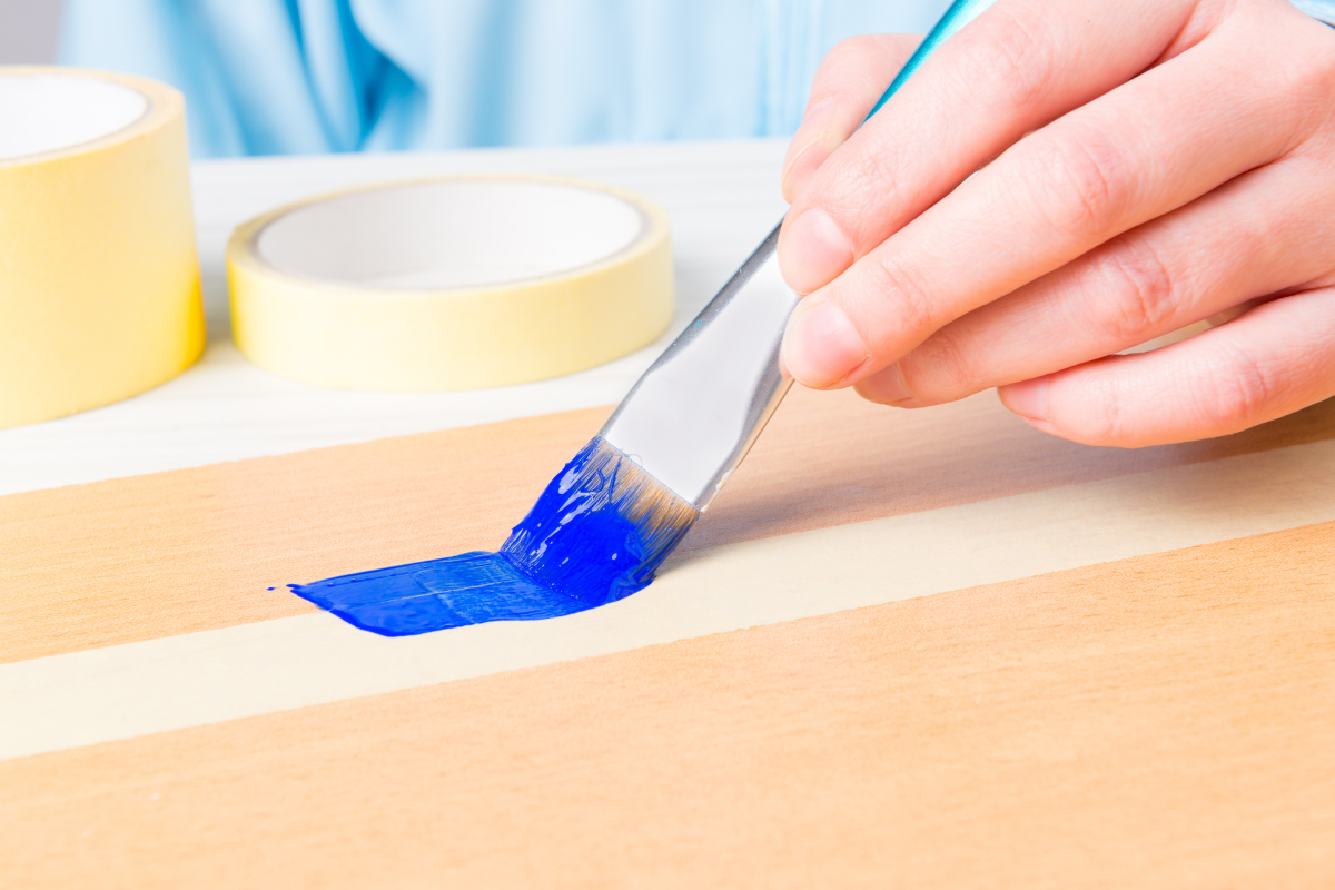 blue paint on paint brush, painting between tape