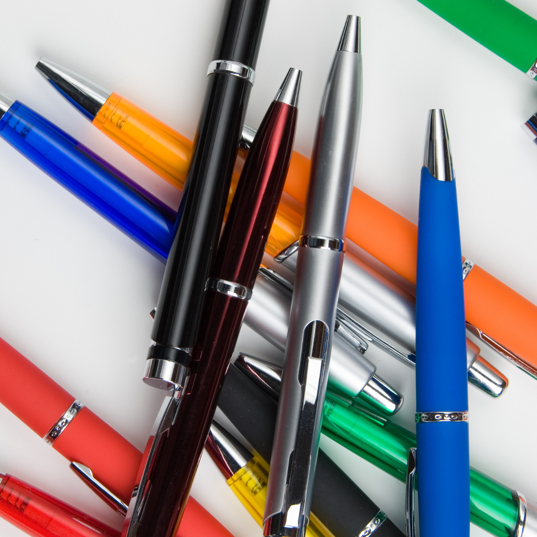 brightly colored pens in a pile on a white background